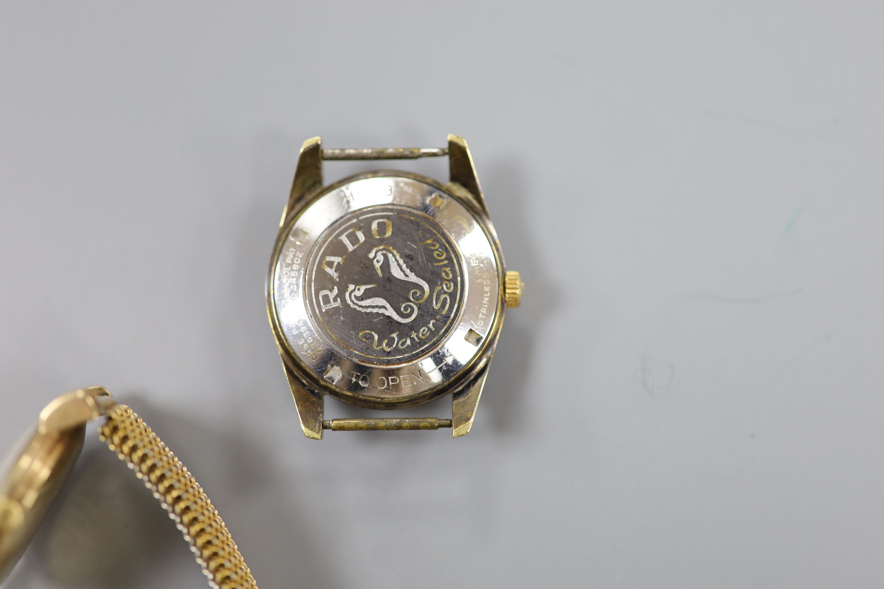 A gentleman's 9ct gold Baume manual wind wrist watch, on a gilt metal flexible strap and a gentleman's steel Rado Gren Horse wrist watch, no strap.